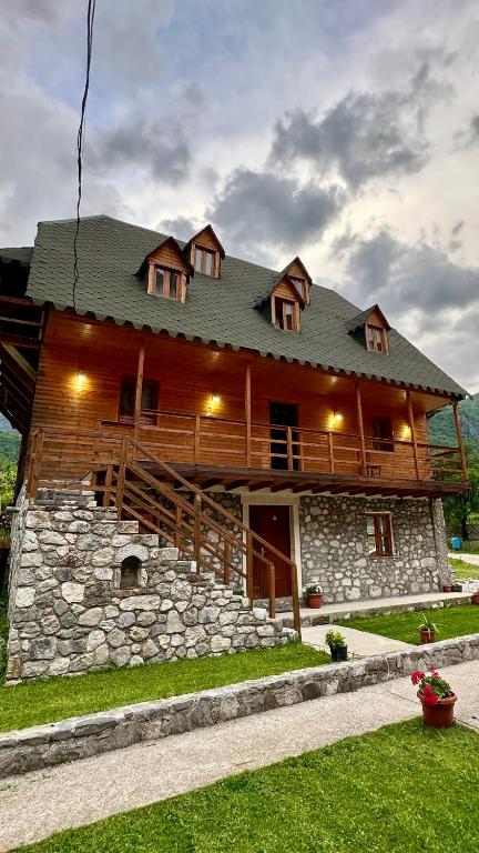 a large wooden house with a stone at Bujtina Vellezerit Grrela in Theth
