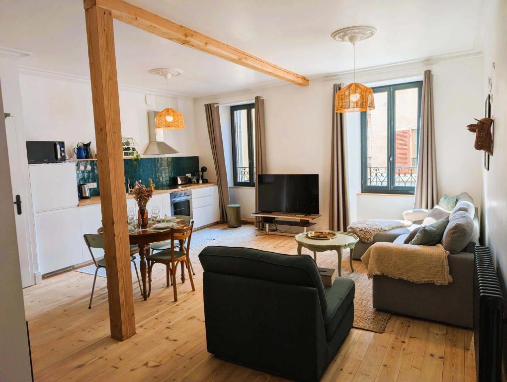 a living room with a couch and a table at Chez flader, deux pièces de 55m2 centre historique in Langeac