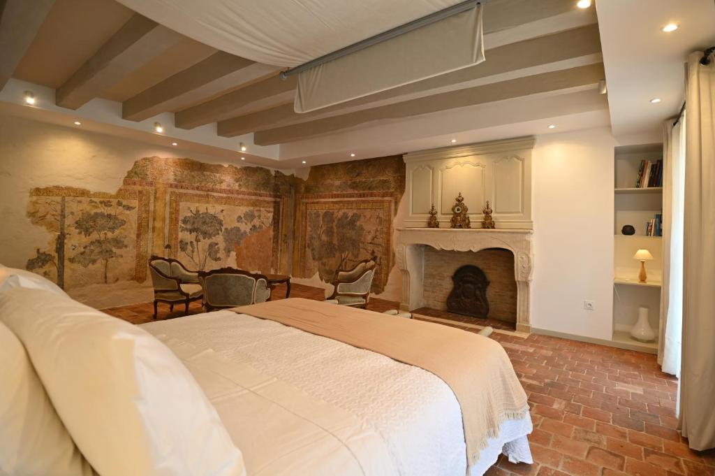 a bedroom with a large bed and a fireplace at Chambres d'hôtes de La Tour Morillon in Saint-Amand-Montrond