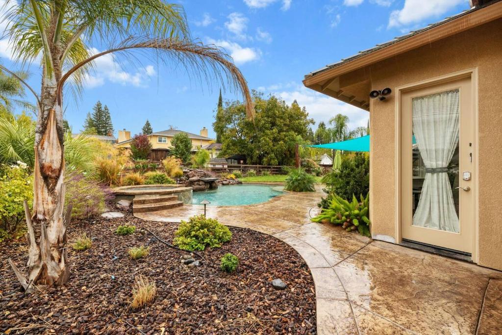 a backyard with a pool and a house at Tranquil Retreat: Pool, Spa, Firepit, Peloton, WFH in Orangevale