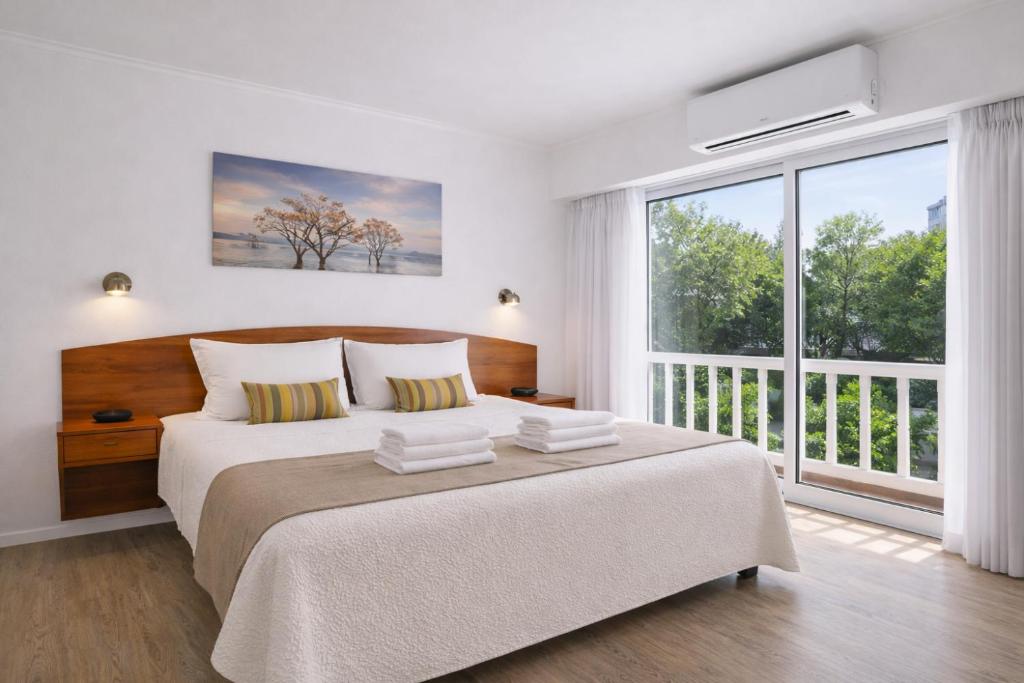 een slaapkamer met een groot bed en een groot raam bij Hotel España in Mar del Plata