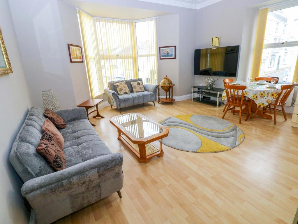 a living room with a couch and a table at 1 Hilton Flats in Tenby