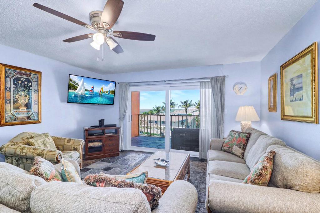 a living room with two couches and a ceiling fan at Reef Club 304 in Clearwater Beach