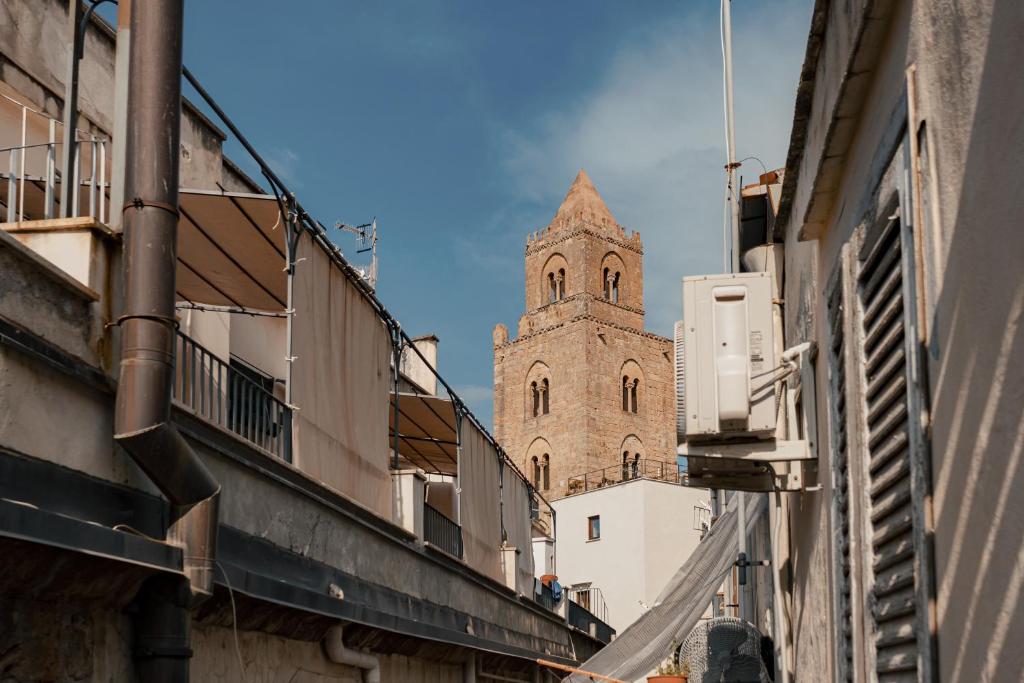 a tall building with a clock tower in the background at Dimora Costa Cefalù in Cefalù