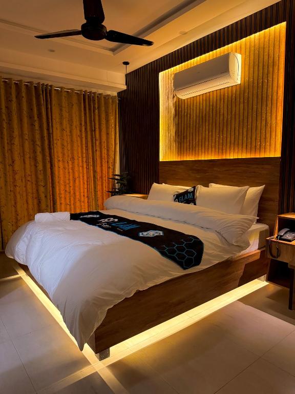a bedroom with a large white bed with a ceiling at Go Glam Hotels Bahria Town in Rawalpindi