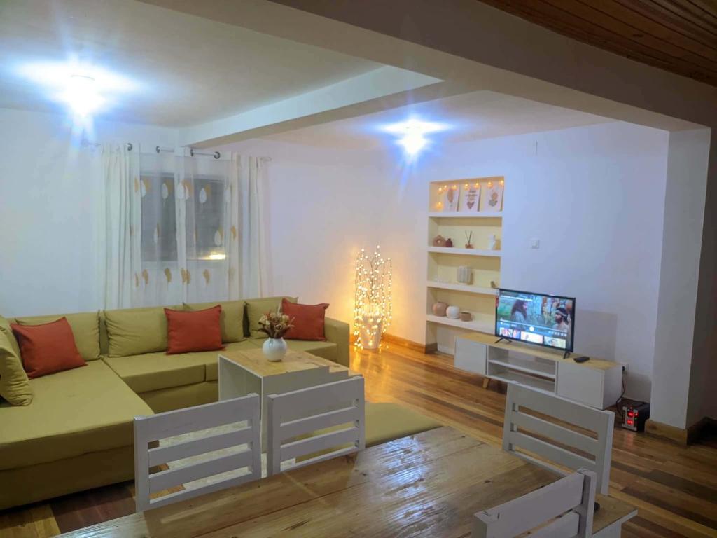 a living room with a couch and a television at villa EMMANUEL -2 in Belanitra