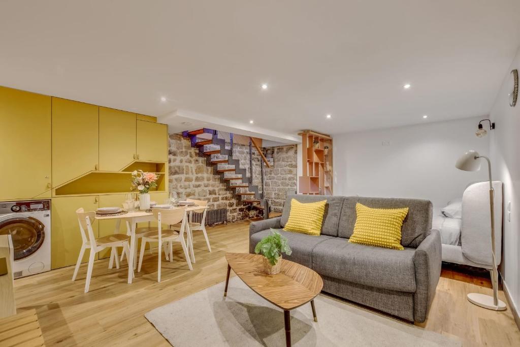 a living room with a couch and a table at Basement studio- Montparnasse Station in Paris