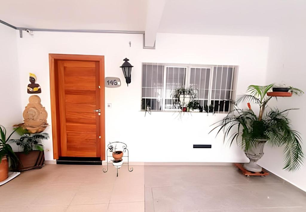 a hallway with potted plants and a door at Expo SP, Metrô e Congonhas in São Paulo