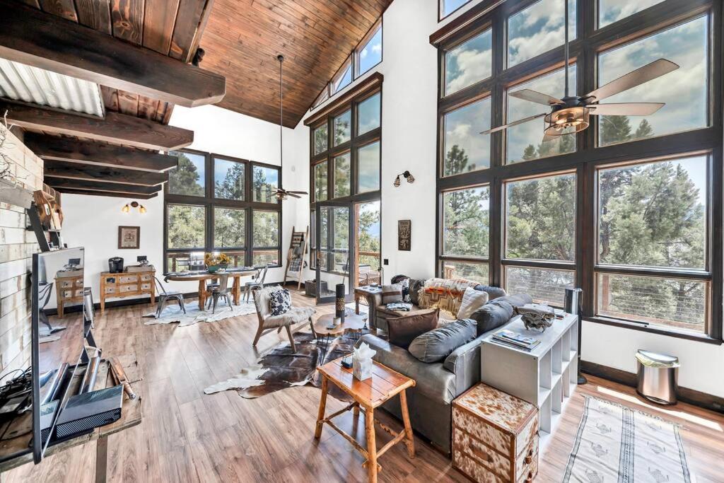 a living room with large windows and a couch at Authentic 4BR Big Bear Cabin, Dog-Friendly with Deck in Big Bear City