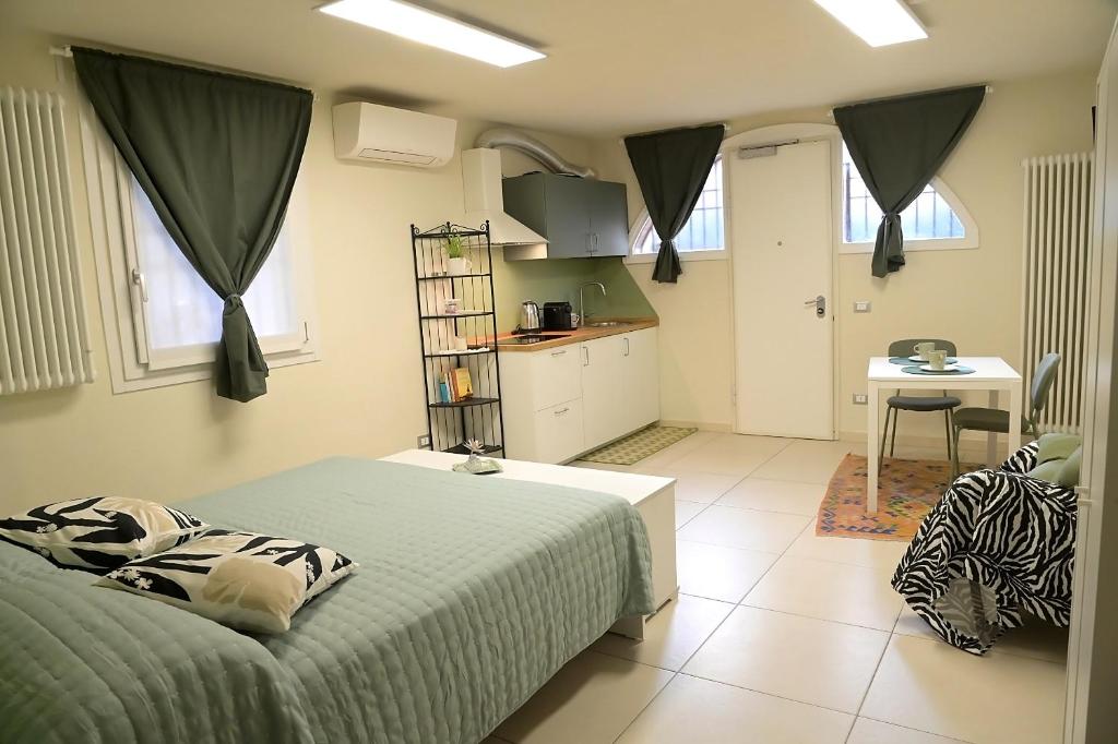 a bedroom with a bed and a kitchen with a table at Volta B&B Imola in Imola