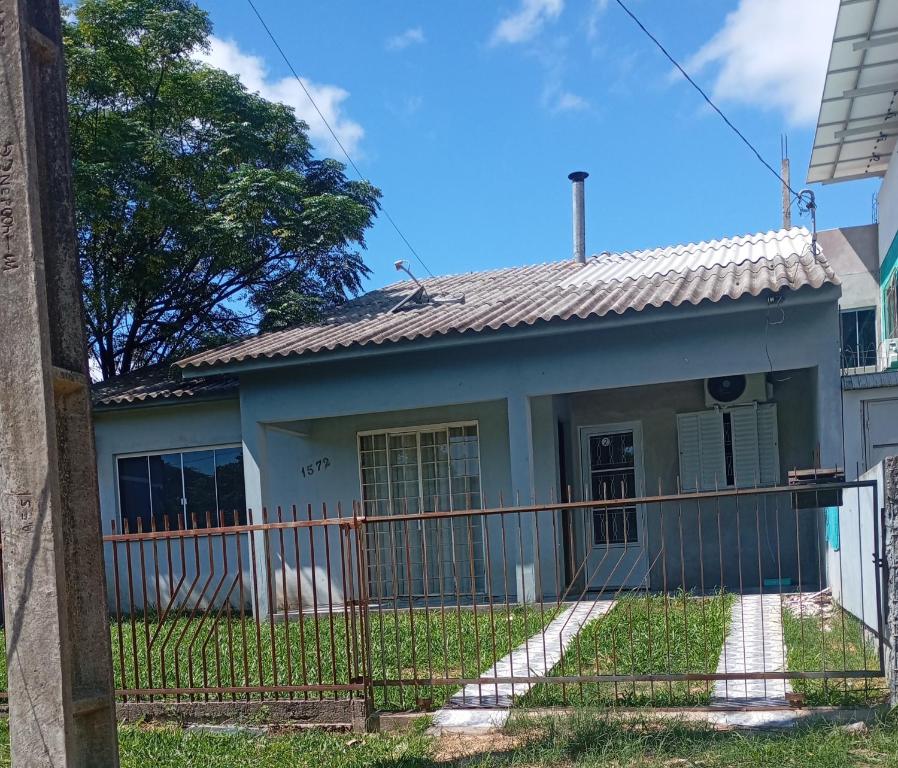 ein Haus mit einem Zaun davor in der Unterkunft Quarto suíte 2 in Itaqui