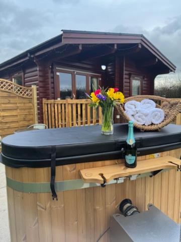 a wooden cabin with a table with flowers on it at Pheasant Lodge Scottish Borders in Carlisle