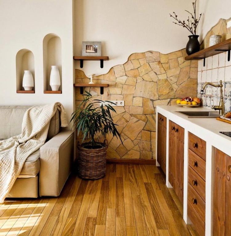 a kitchen with wooden floors and a stone wall at Mayachok Boutique hotel in Kyiv