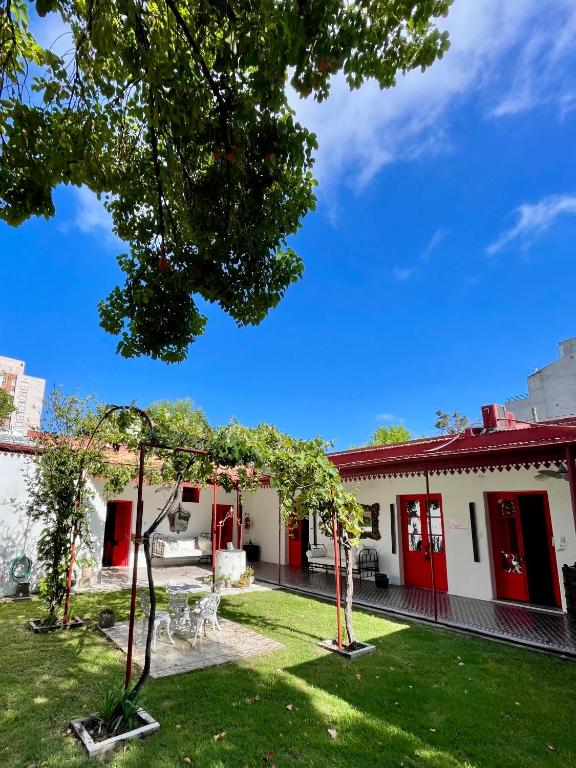 a house with red doors and a yard at Casa Cielo Cardenal in Concepción del Uruguay