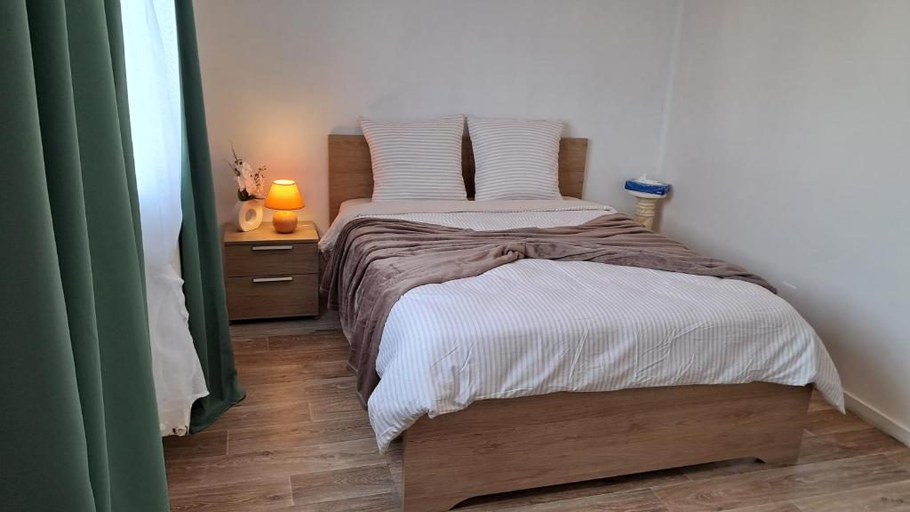 a bedroom with a twin bed with a nightstand and a bed sidx sidx sidx at Appartement T2 cosy in Canteleu