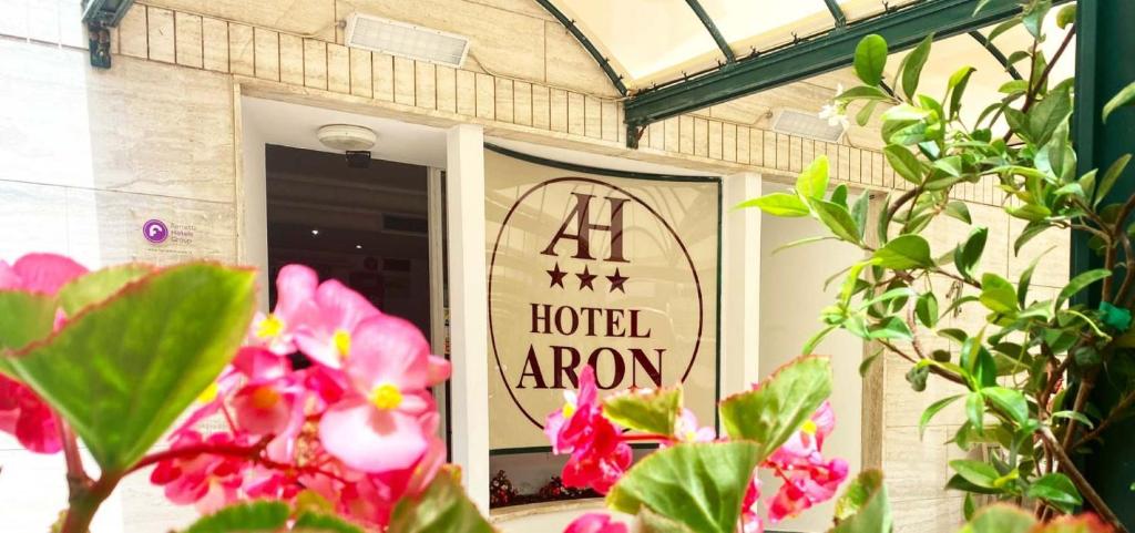 a hotel arrow sign on a door with flowers at Hotel Aron Rimini in Rimini