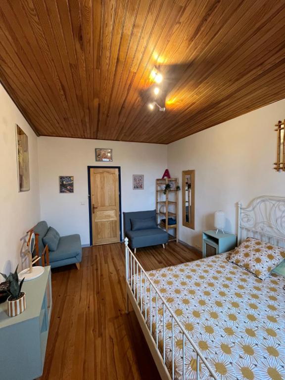 a bedroom with a bed and a wooden ceiling at Les maisons de Gaïa Chambre d'hôte climatisée in Tuchan