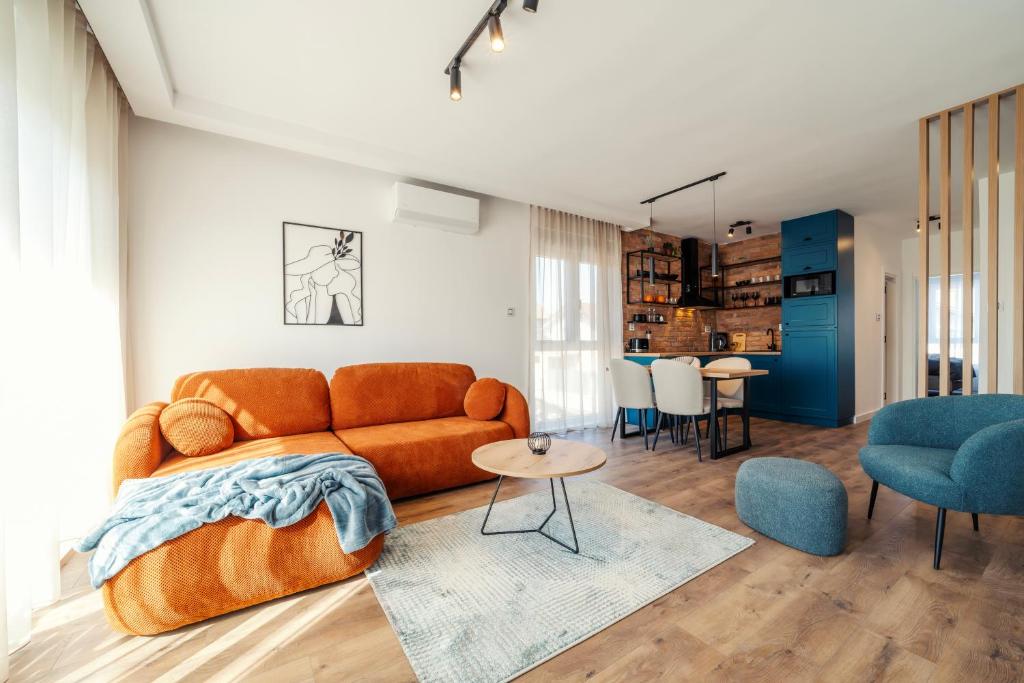 a living room with a couch and a table at Zara Garden Apartment in Novi Sad