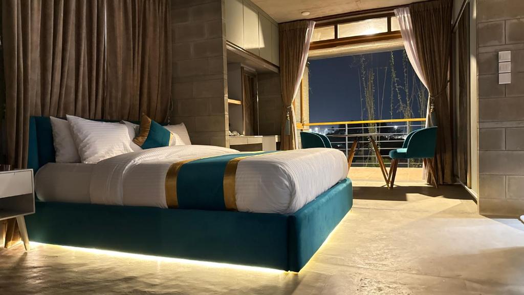 a bedroom with a large bed with a balcony at Privee Dhaka - PRIVEE RESORT & RESTAURANT in Bholānāthpur