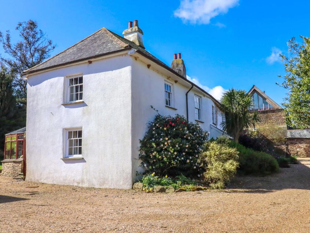 an old white house with a bush in front of it at Oak Tree in Halwell