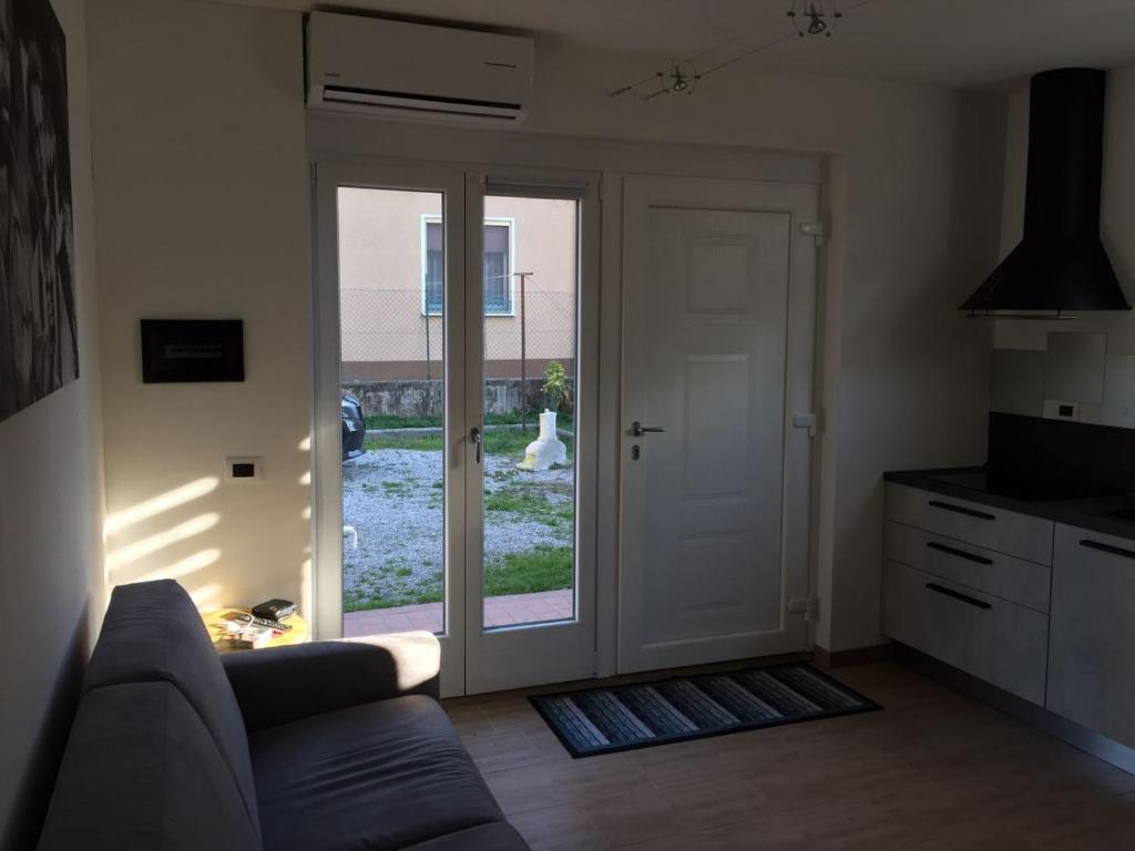 salon z kanapą i przesuwnymi szklanymi drzwiami w obiekcie Guest House Persico w mieście Desenzano del Garda