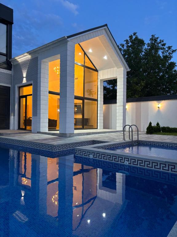 a swimming pool in front of a house at Palmen Villa Gabala in Gabala