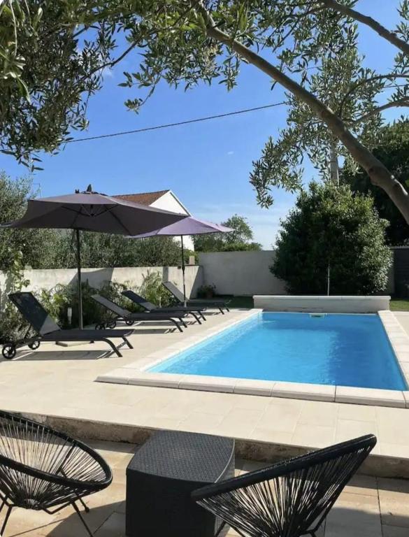 a swimming pool with two chairs and an umbrella at HH Antona with Private Pool in Puljane