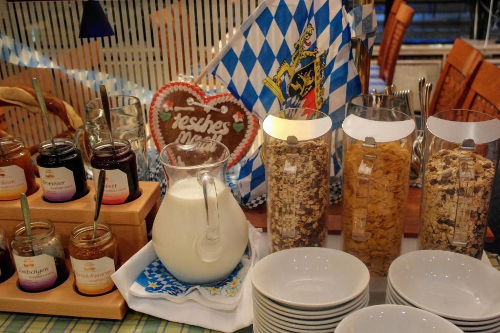 a table with jars of food and plates with milk at Hotel Daniel in Munich
