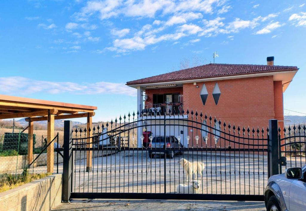a goat standing behind a fence in front of a house at Affittacamere Rocca in Montefortino