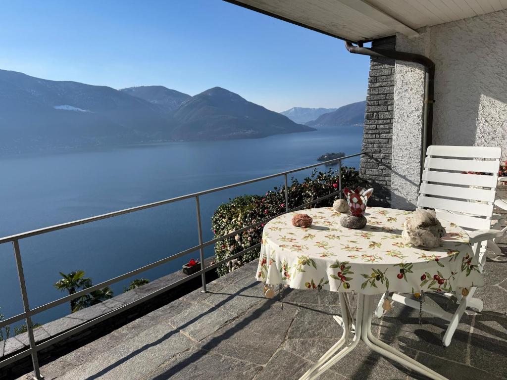 a table and chairs on a balcony with a view of the water at Casa Rocca Nera by HolAp in Ronco sopra Ascona