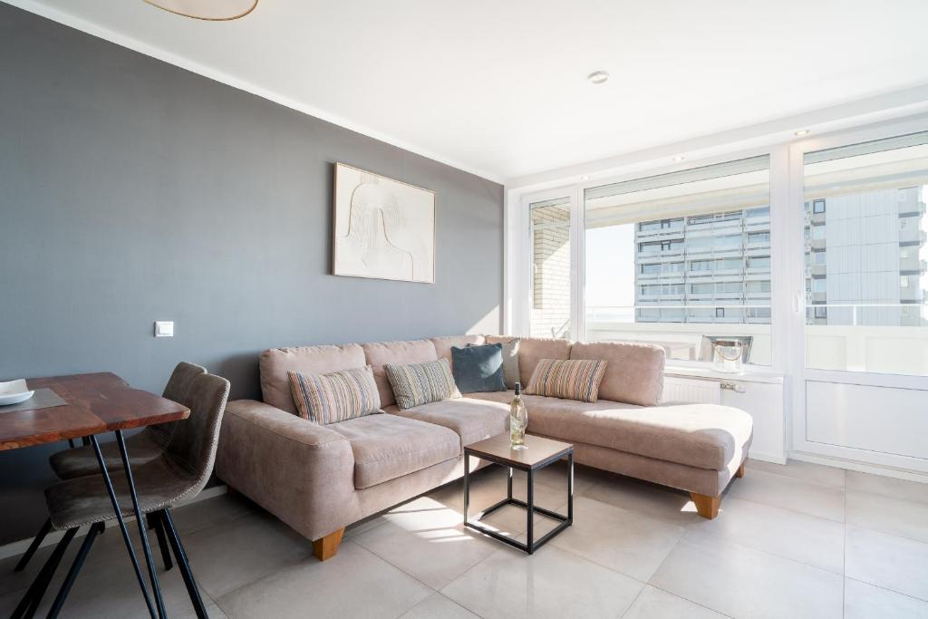 a living room with a couch and a table at Panoramic App B07-1 in Sierksdorf