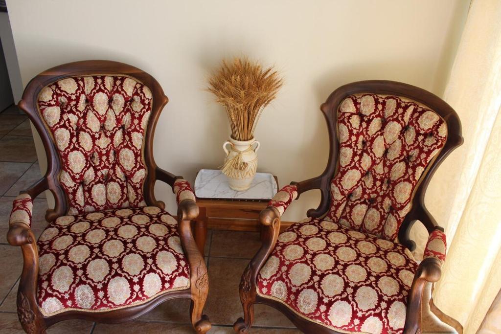 two chairs sitting next to a table with a vase at Cozy and Central Bachelor Flat in Wellington