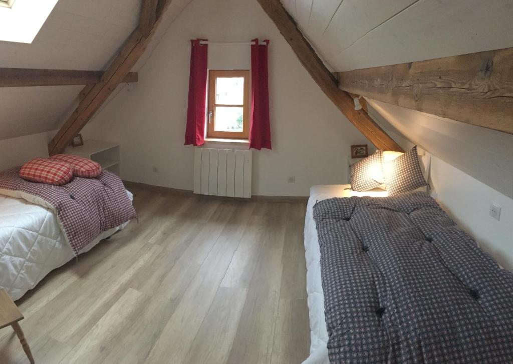 a attic bedroom with two beds and a window at Gîte sainte Famille in Ottrott