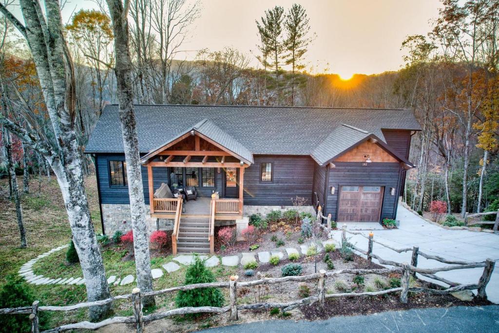 a wooden house with a porch in the woods at Highland House in Banner Elk