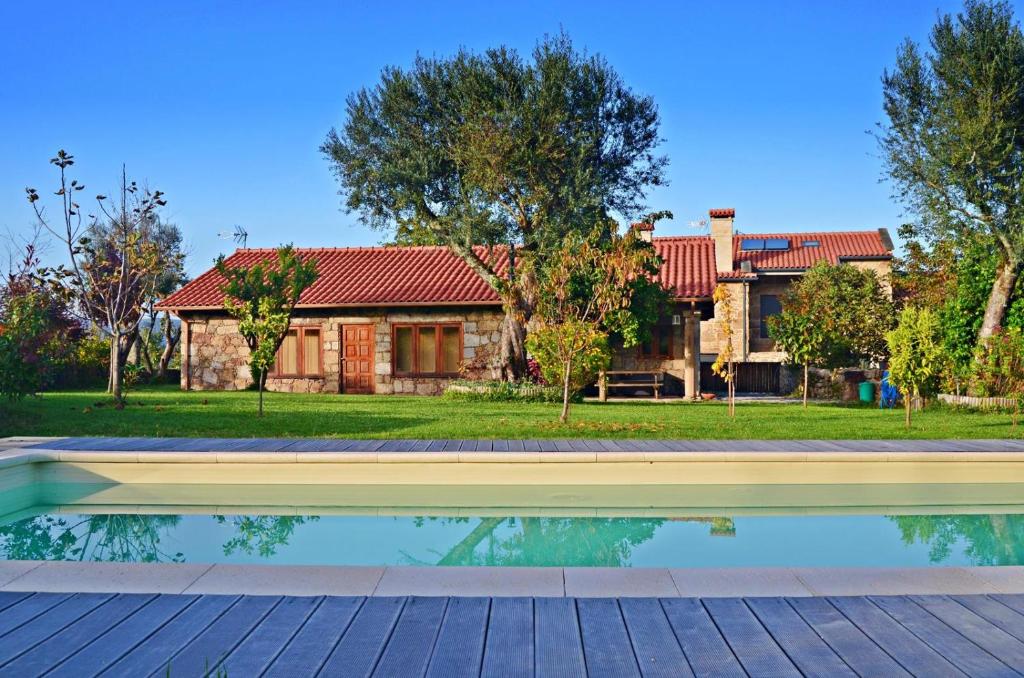 una casa con piscina frente a una casa en Casa de Reborido, en Ponte da Barca