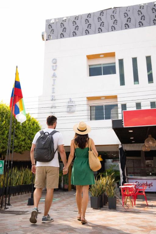 a man and woman walking down a street holding hands at Hotel Velero Guajira Real in Fonseca