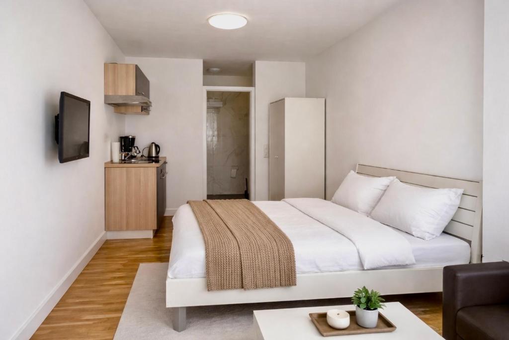 a bedroom with a white bed and a couch at baadenbergerstay A in Cologne