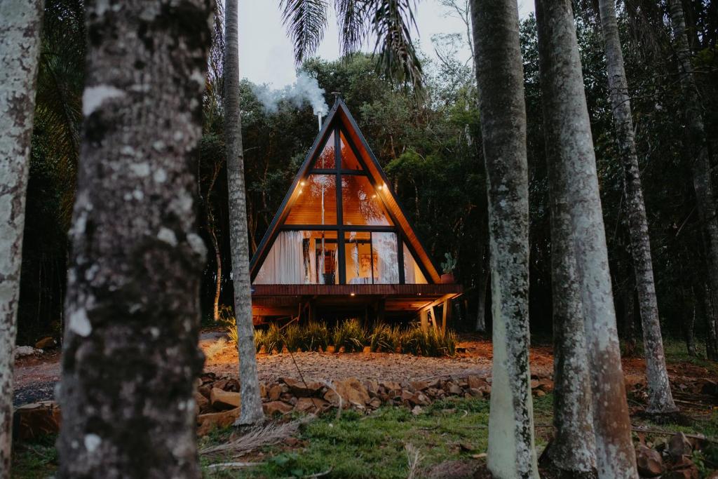 a frame house in the woods with trees at Canaã Cabanas in Mariópolis