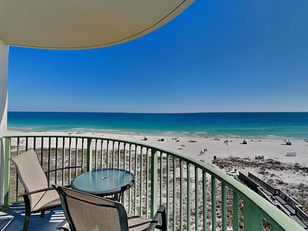 a balcony with chairs and a table and the beach at Perdido Towers #604 in Perdido Key