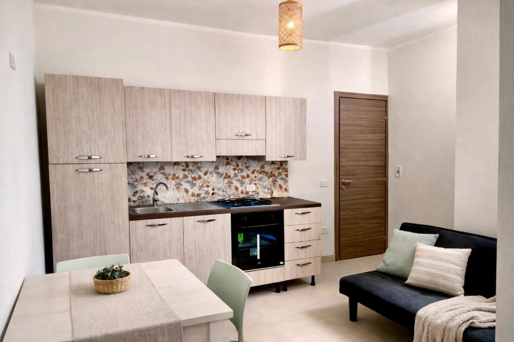 a kitchen and living room with a table and a couch at My Home Lampedusa in Lampedusa