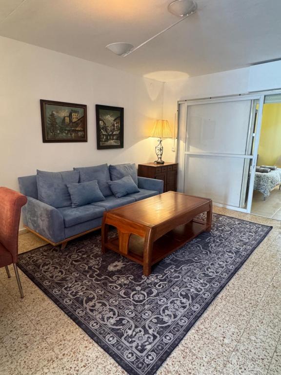 a living room with a blue couch and a coffee table at צימר הר הגמל in Mitzpe Ramon