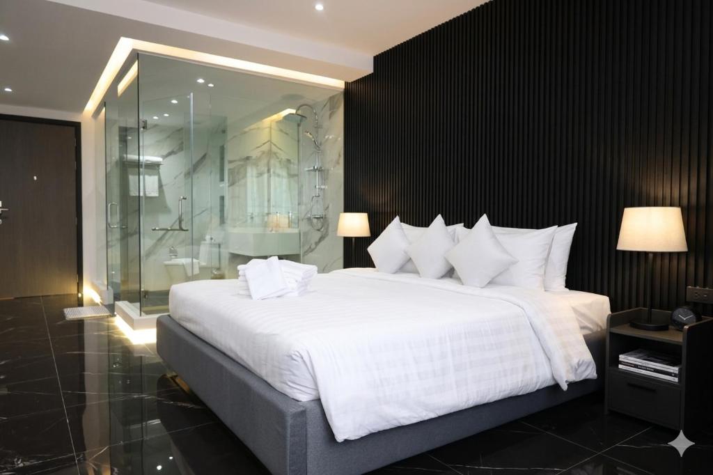 a bedroom with a large white bed and a shower at Stylish Condo Near Nai Harn Beach Full Facilities Utopia M720 in Rawai Beach
