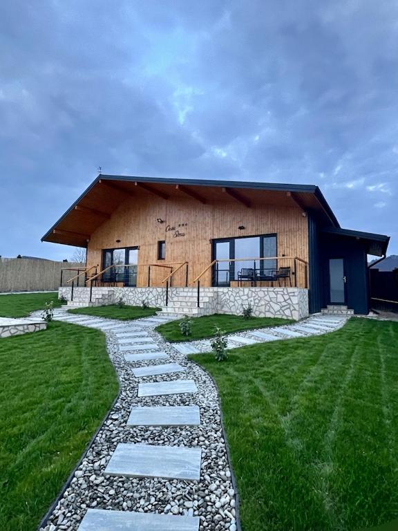a house with a stone path in front of it at Casa Sima 2 in Curtea de Argeş