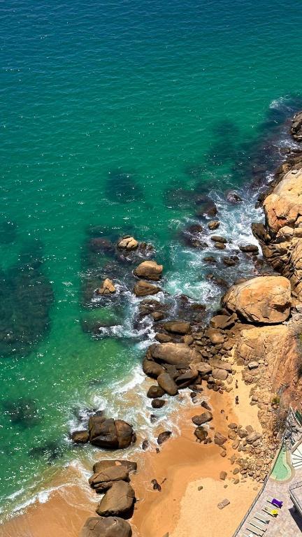 a view of a beach with green water and rocks at Suite con vista al mar Acapulco in Acapulco