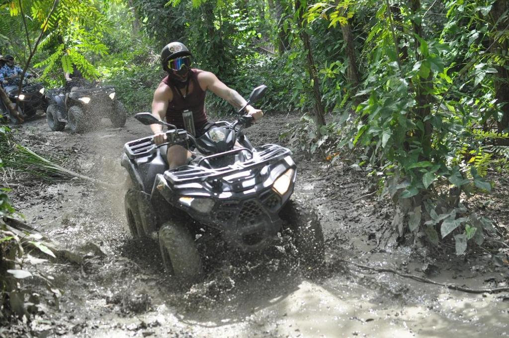 a man riding a atv down a muddy trail at City tours in Colorado