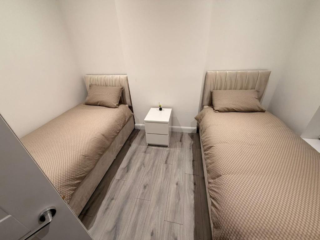 two beds sitting next to each other in a room at The Arch apartment in Bangor