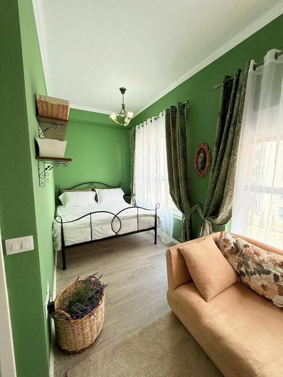 a green room with a bed and a couch at 13 Daily apartments in Tirana