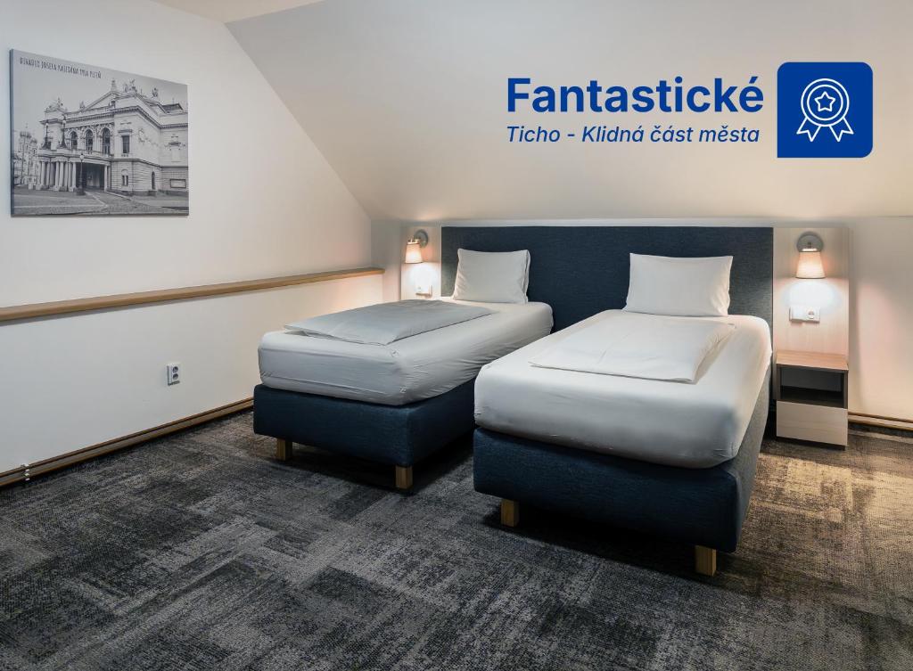 a room with two beds and a sign that reads famitsu taito junior suite at Wellness penzion a restaurace U Gigantu in Pilsen