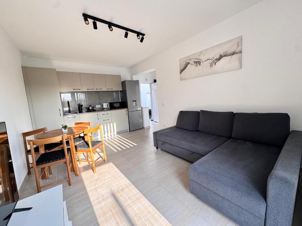 a living room with a couch and a table and a kitchen at Studio in 2 Mai,Quiet,Spacious,Garden,Separate Bedroom - Donilads Properties - Home Everywhere in 2 Mai