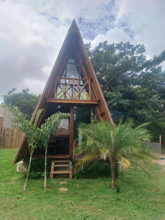a frame house with a thatched roof on a field at Chalé Garças in Chapada dos Guimarães